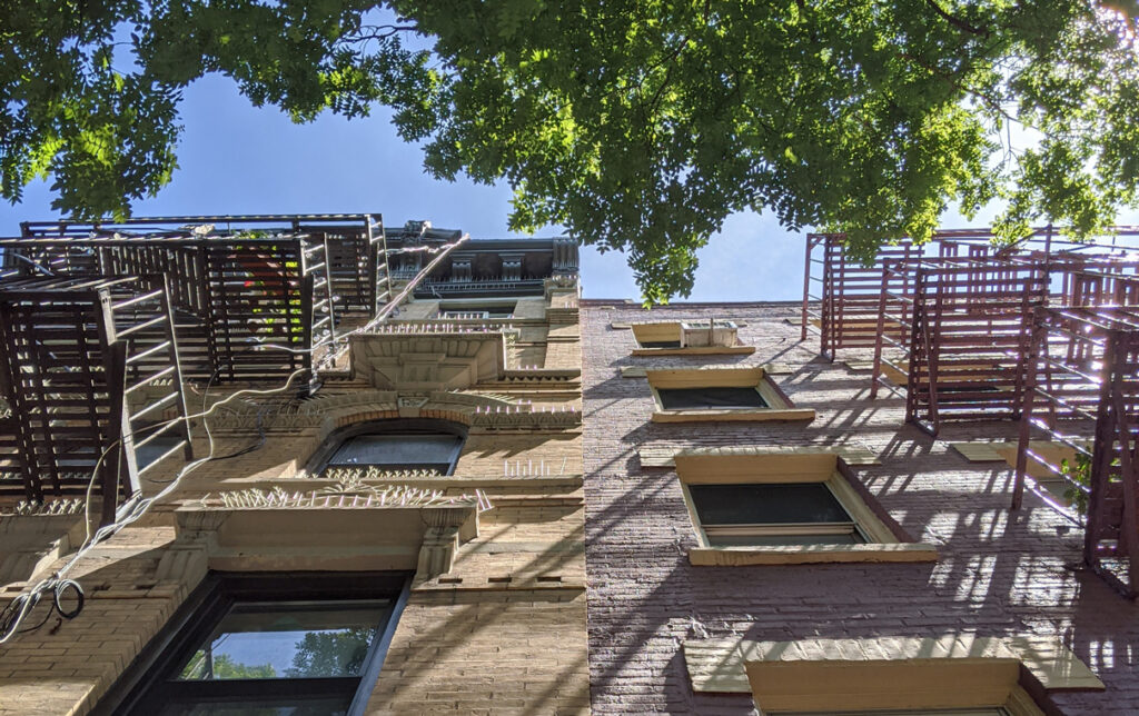 looking up towards the sky at an apartment and trees